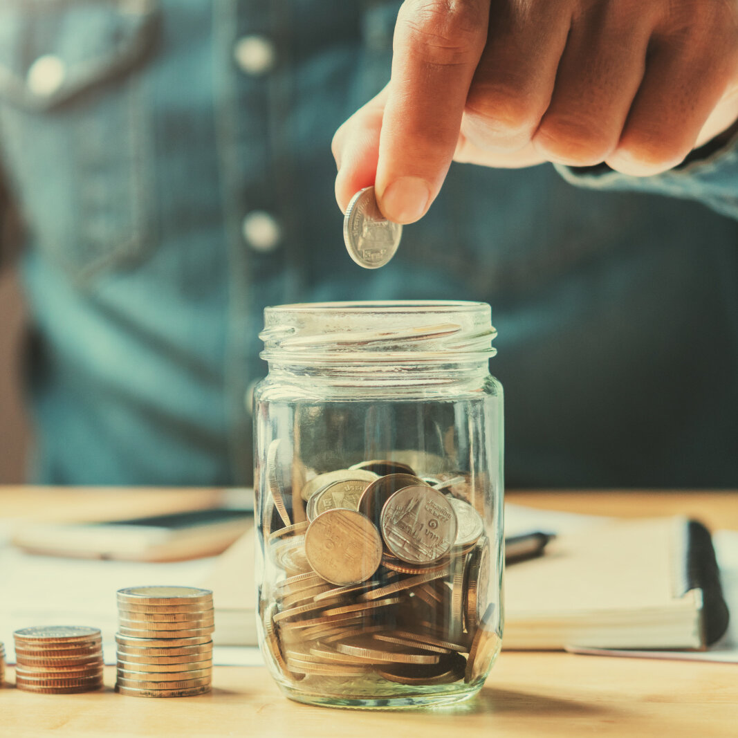 Zehnder_ALL_Sparen businessman holding coins putting in glass. concept saving money for finance accounting
