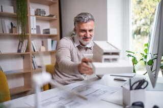 Energy-efficient building Architect holding a building model while planning an energy-efficient construction project